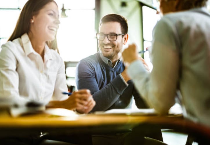 Couple smiling while signing paperwork