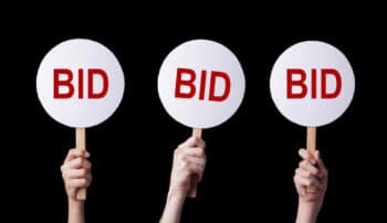 Bidders' hands lifting auction paddles