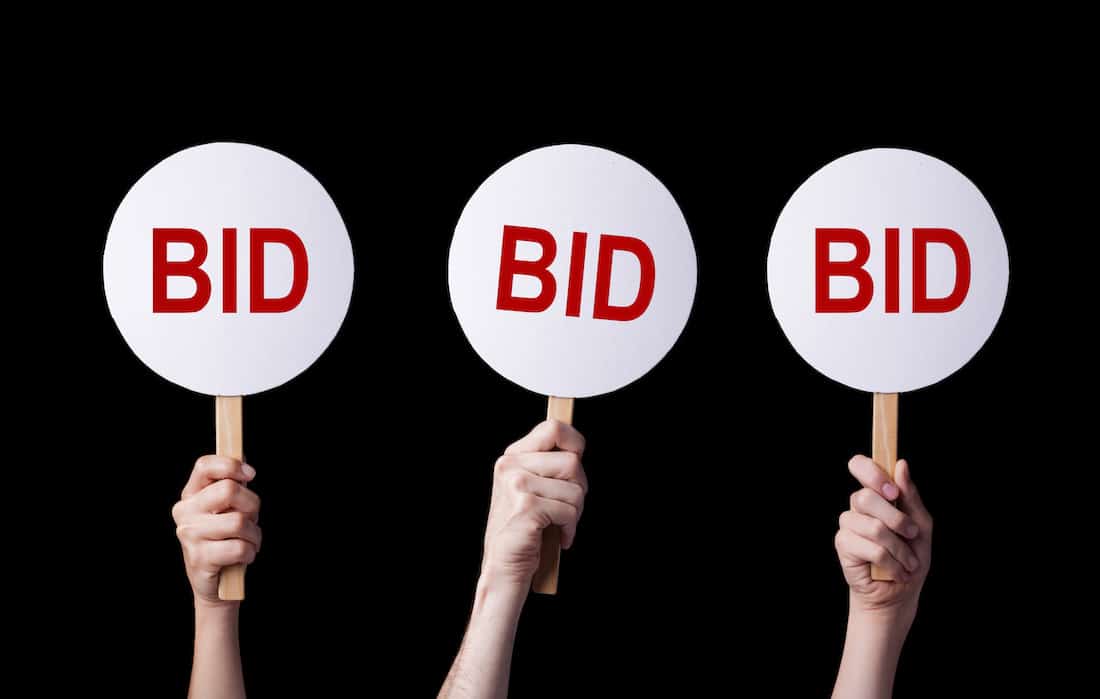 Bidders' hands lifting auction paddles