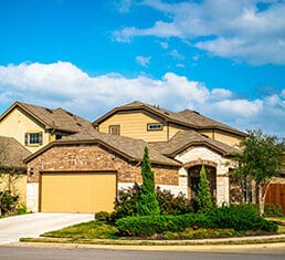 Real estate suburb development in Austin Texas nice new builds community neighborhood in new suburbia homes and houses with two car garage and nice trees and landscaping